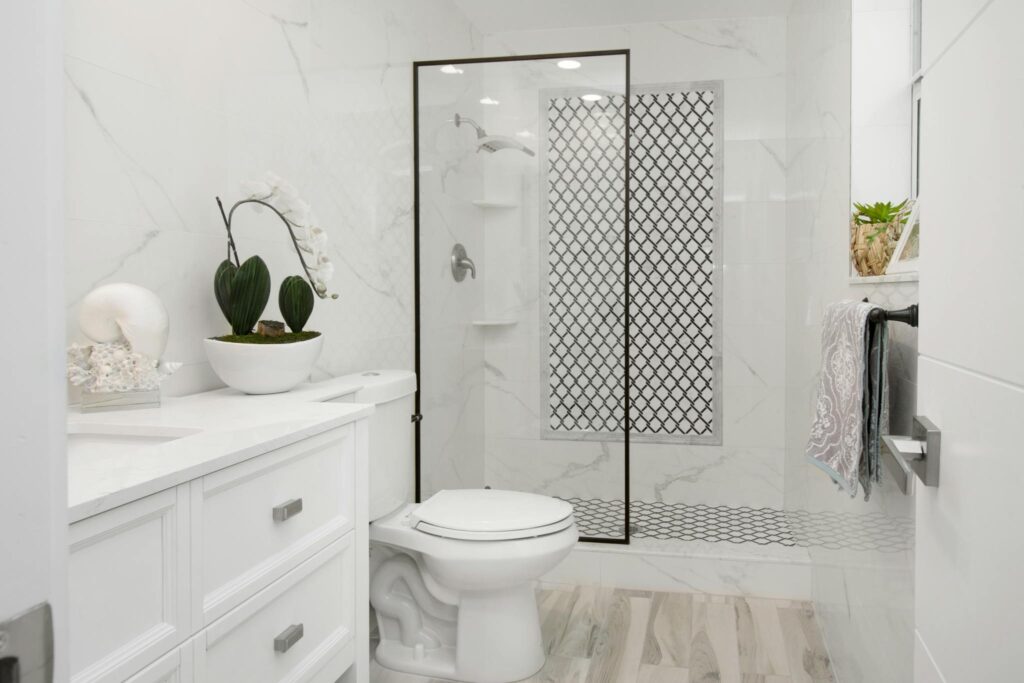 Elegant white bathroom with contemporary design featuring minimalist decor and a glass shower.